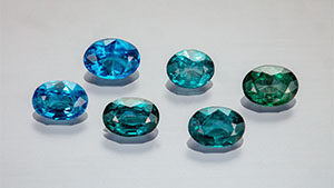 Figure 1. Suite of faceted nickel-diffused spinel (0.674–1.009 ct) showing the range of color from blue to bluish green. Photo by Aaron Palke and Diego Sanchez.