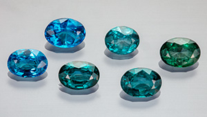 Figure 1. Suite of faceted nickel-diffused spinel (0.67–1.01 ct) showing a range of color from blue to bluish green. Photo by Aaron Palke and Diego Sanchez.